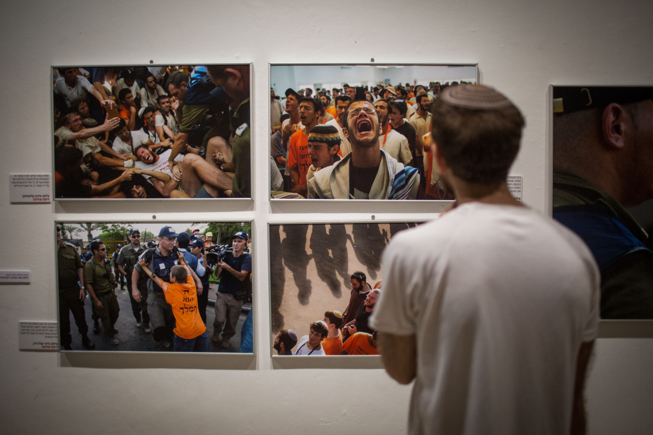 Israelis schauen sich die Ausstellung von Photographien in Jerusalems First Station an, die die Räumung des Siedlungsblocks von GuschKatif im Jahr 2005 dokumentieren. Die Photographien wurden von Photographen der israelischen Tageszeitung Jedi’ot Acharonot aufgenommen. 21. Juli 2015. (Hadas Parush/Flash90)