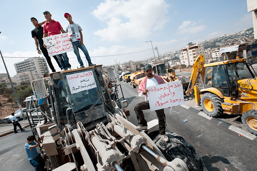  Straßenblockade von palästinensischen Arbeiter*innen, die gegen zu hohe Benzin- und Lebensmittelpreise protestieren. Bethlehem in der Westbank, 2012. Foto: Activestills