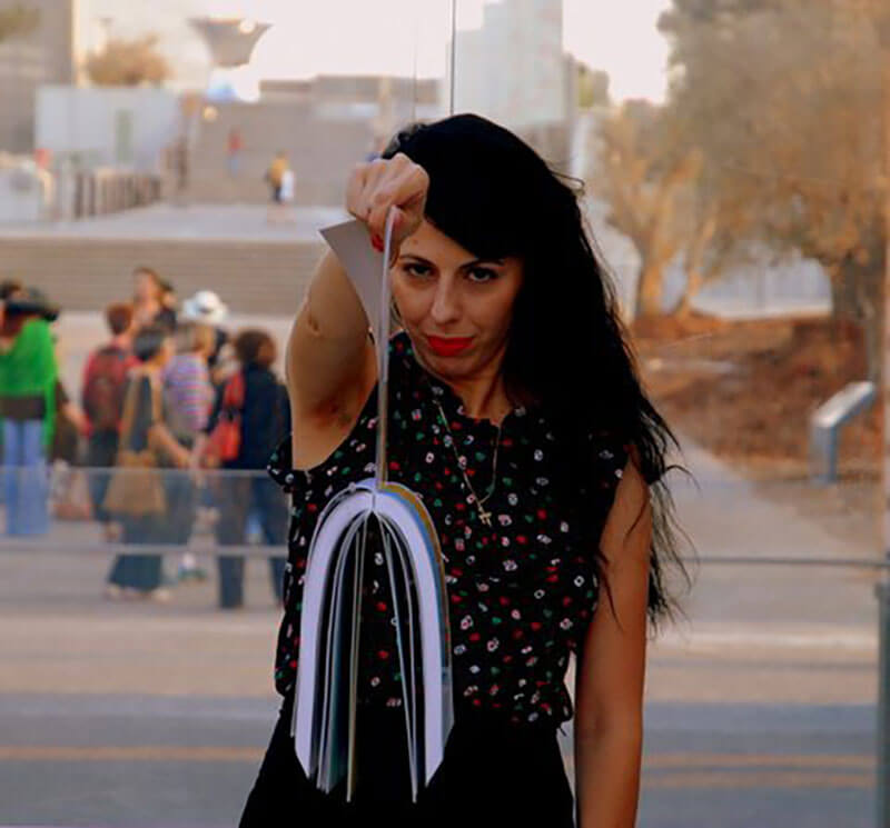 "6 von 511 ein Tribute zu Meir Gal". Ortal Ben Dayan hält die sechs Seiten die Mizrachi Künstler im Kunstkatalog "100 Jahre israelische Kunst" von Igal Zalmona repräsentieren. 2011.